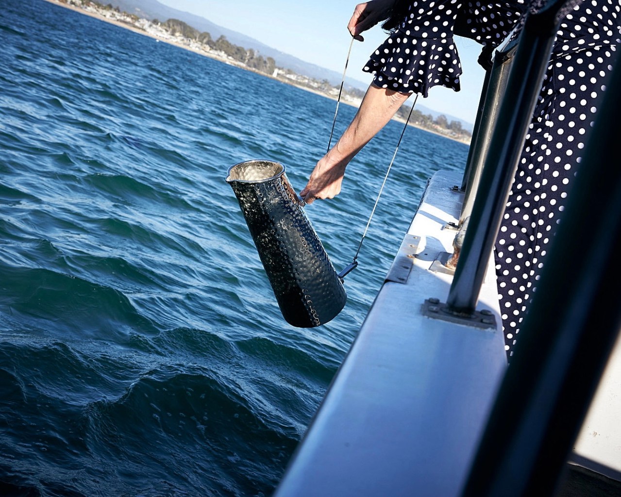 person pouring ashes into monterey bay